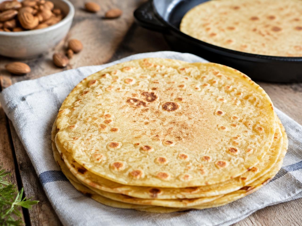 Stapel med keto tortillor på mandelmjöl med gyllene stekfläckar